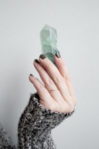 woman holding green crystal